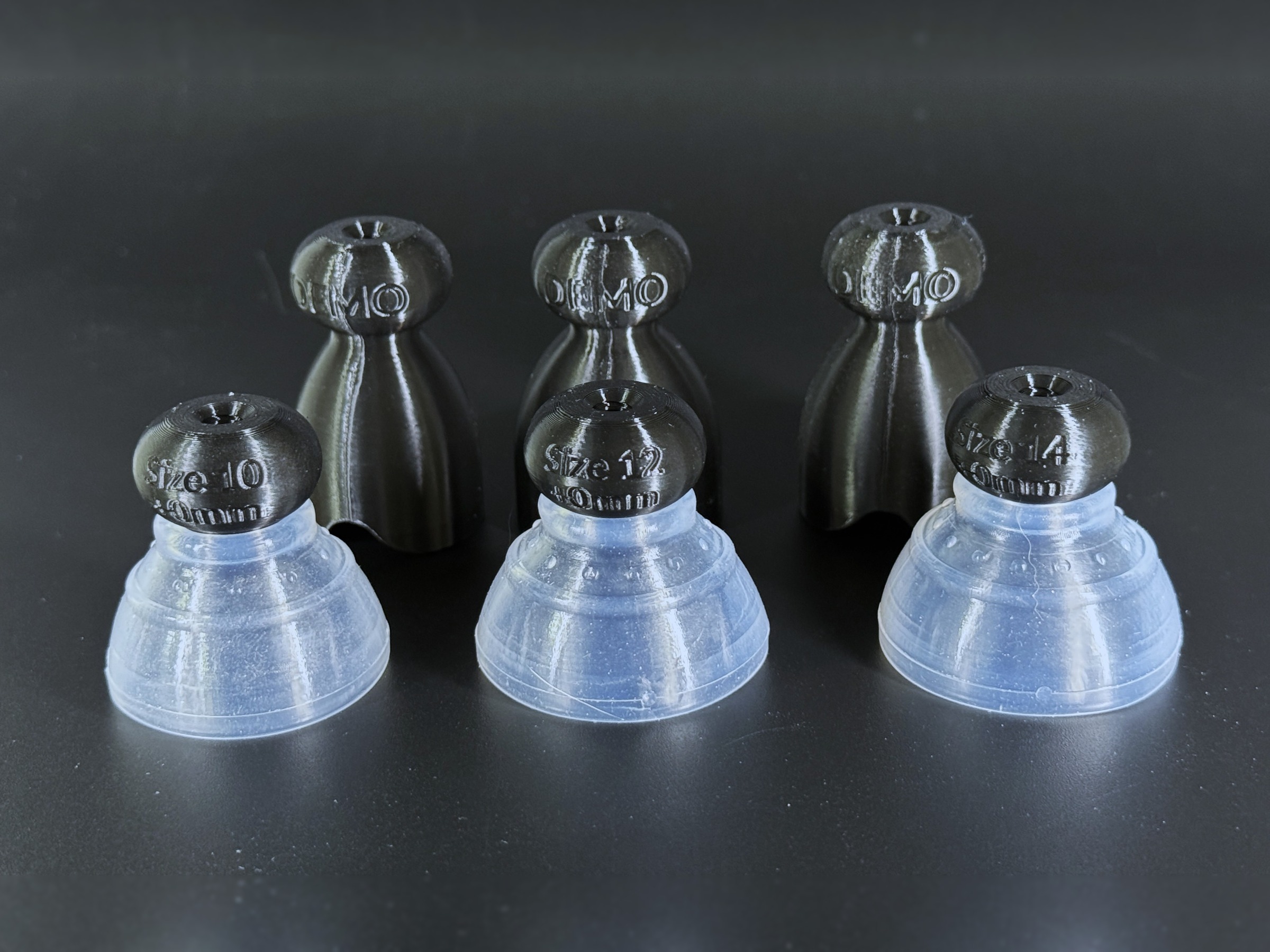 Six demo P-tainers in different sizes, each fitted with a clear silicone gripper.