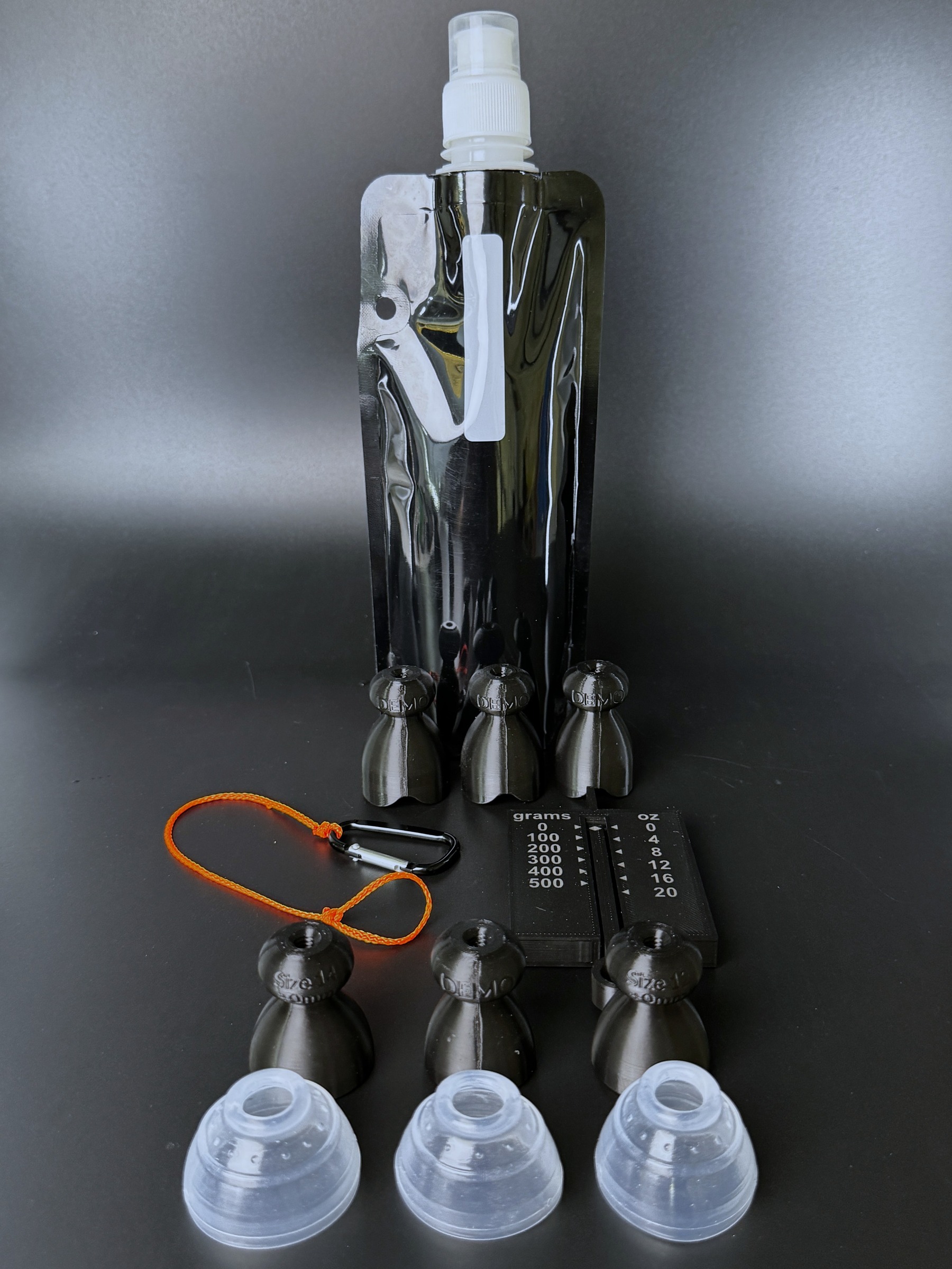 The P-Tainer Demo Kit laid out: collapsible water bottle, three demo P-tainers with grippers, weight gauge, and tugging string.