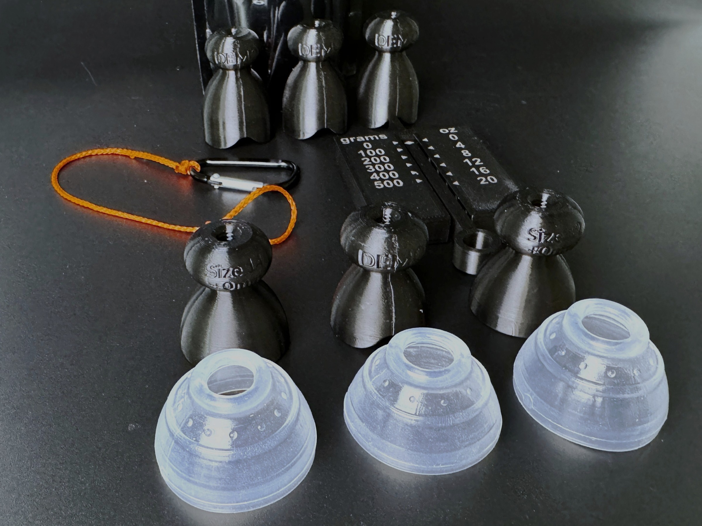 Demo P-tainers with clear silicone grippers alongside the weight gauge and orange tugging string.