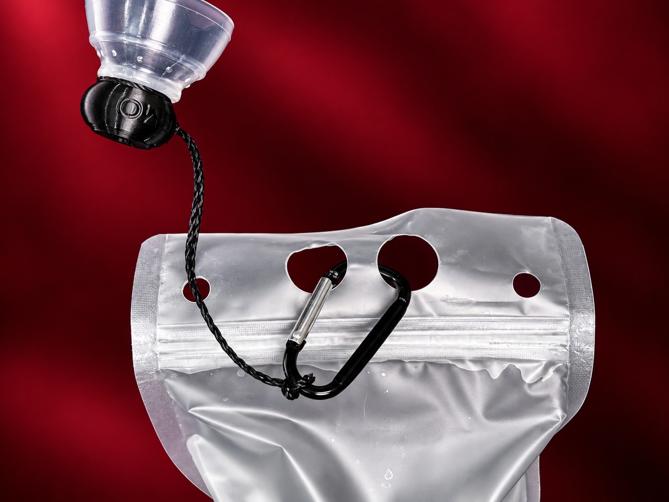 Tugging string clipped by carabiner to the collapsible water bottle, with a demo P-tainer at the other end.