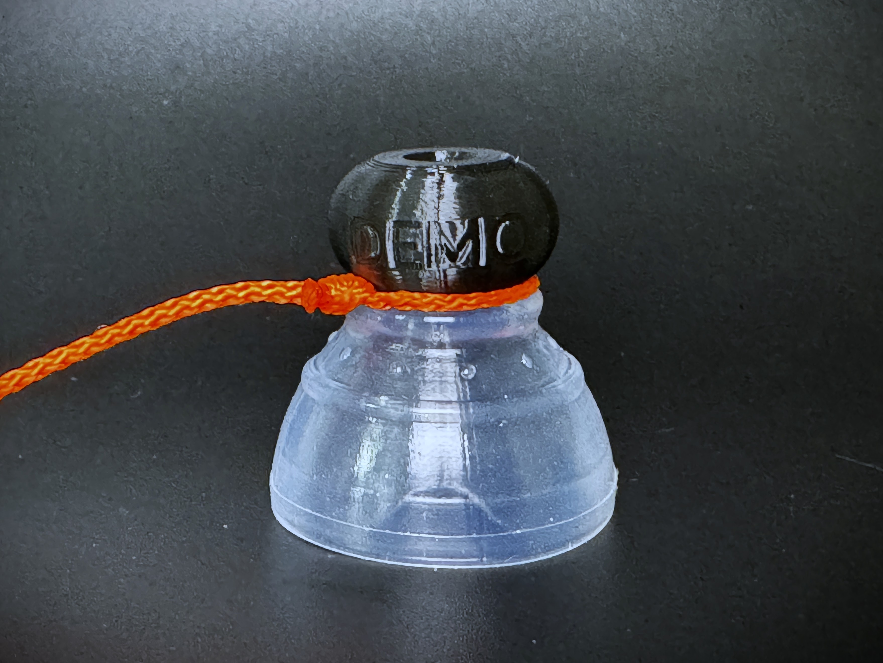 The tugging string looped around the threaded knob end of a P-tainer.