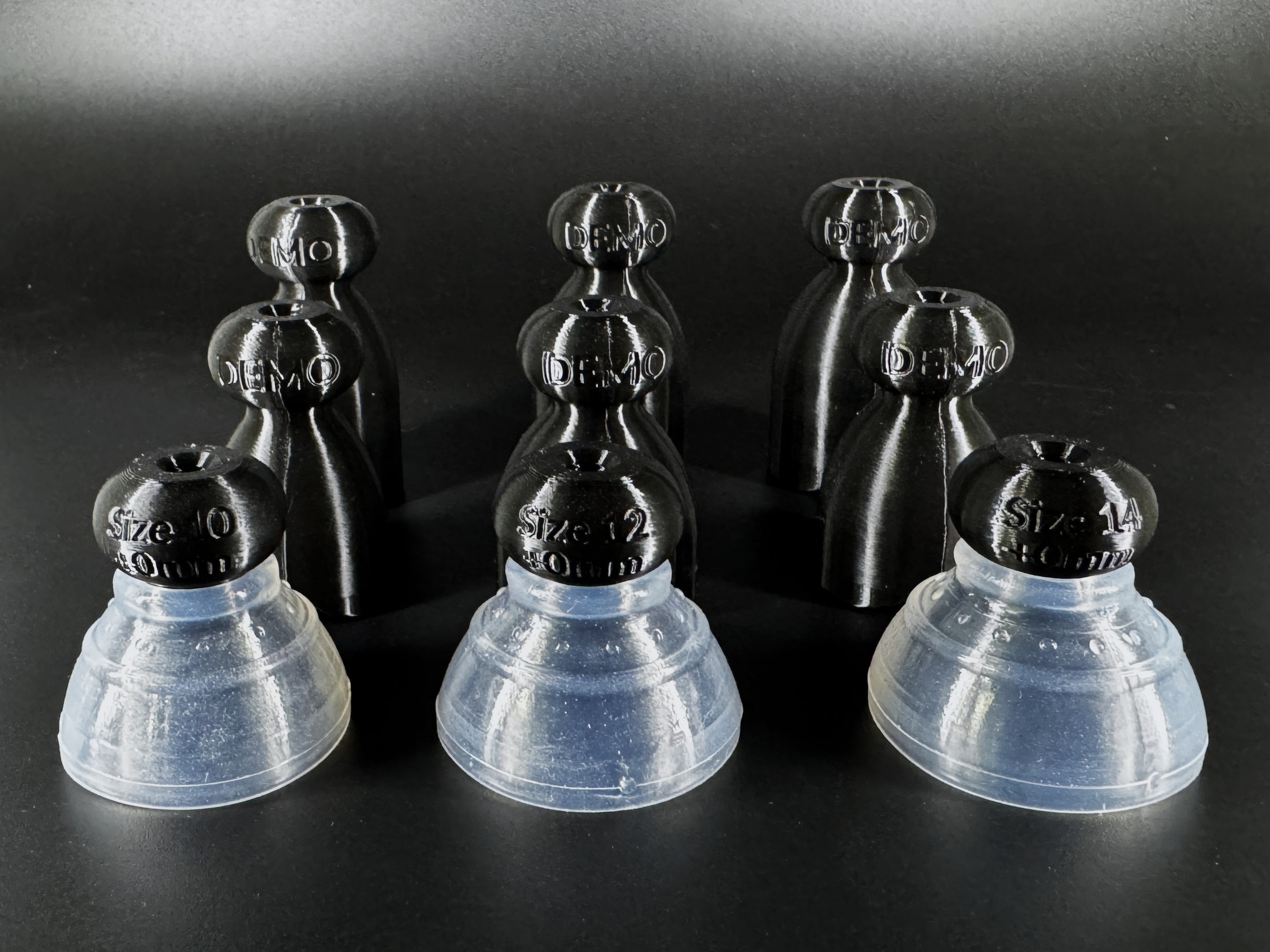 Nine demo P-tainers arranged in three diameters and three lengths, each marked with its size, alongside three stiff silicone grippers.