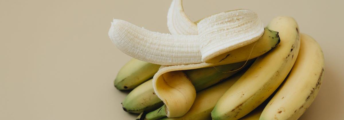 A half-peeled banana on a plain background