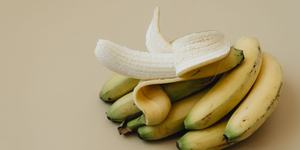 A half-peeled banana on a plain background