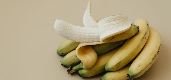 A half-peeled banana on a plain background