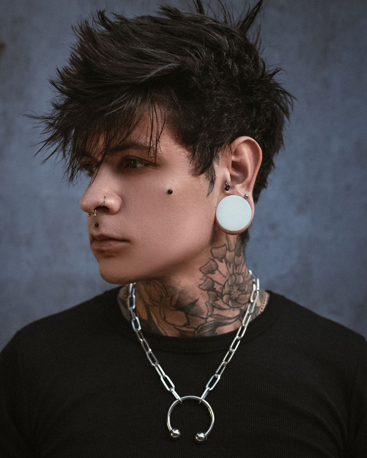 A stretched earlobe holding a large circular plug, an everyday example of skin expanding under sustained tension