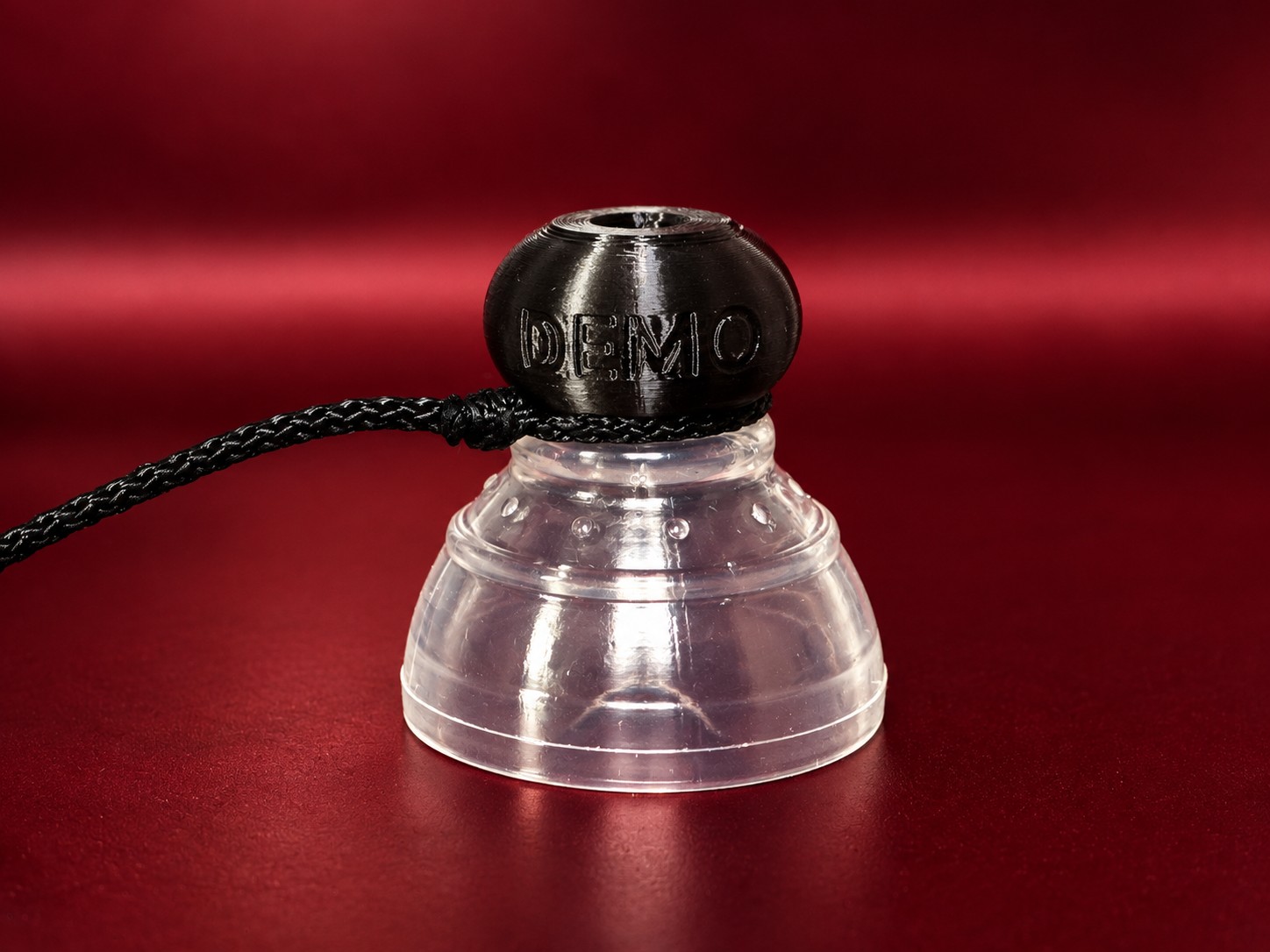 A demo P-tainer with a gripper fitted and the tugging string looped around the threaded knob end.